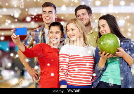 happy friends with smartphone in bowling club Stock Photo