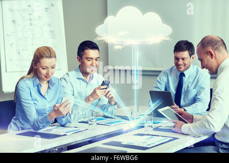 smiling business people with gadgets in office Stock Photo
