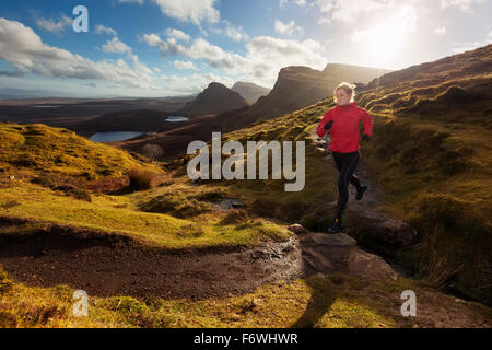 Young woman running on a trail, Quiraing, Trotternish peninsula, Isle of Skye, Scotland, United Kingdom Stock Photo