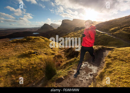 Young woman running on a trail, Quiraing, Trotternish peninsula, Isle of Skye, Scotland, United Kingdom Stock Photo