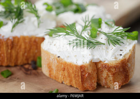 crunchy baguette slices with cream cheese and herbs Stock Photo