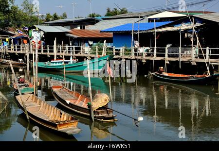Samut Songkhram:   Old wooden fishing boats docked in front of a cluster of Thai houses at a small fishing village Stock Photo