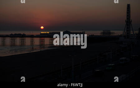 Sunset over Brighton Pier, showing the Brighton Wheel and the remains of the West Pier in the background Stock Photo