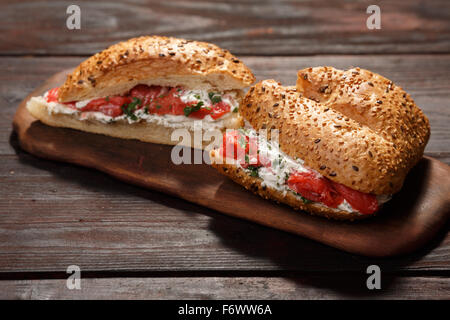 Sandwich from wholegrain bread with salmon, mild creamy cheese and herbs Stock Photo