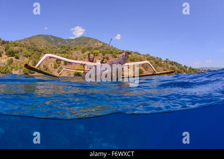 Local Spear Fisherman with outrigger boat, Splitlevel picture, Alor, Indonesia, Sawu Sea, Pantarstrait, Indian Ocean Stock Photo