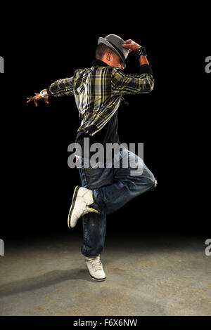 African American hop hop dancer performing over dark background Stock Photo