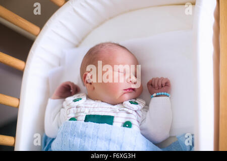 Newborn baby in hospital room. New born child in wooden co-sleeper crib. Infant sleeping in bedside bassinet. Stock Photo