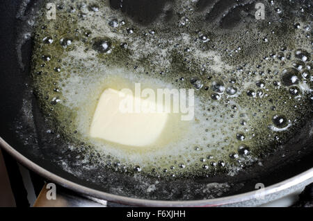 Piece of butter melting on   frying pan. Step by step recipe Stock Photo