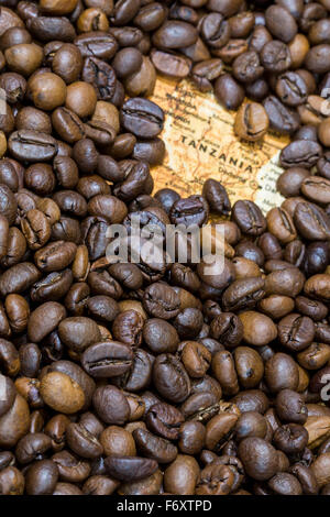 Vintage map of Tanzania covered by a background of roasted coffee beans. This nation is one of the main producers and exporters Stock Photo