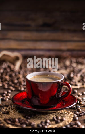 Red coffee cup and beans on wooden background Stock Photo