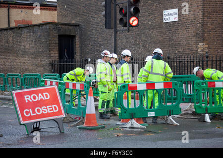 Roadworkers digging up the road Stock Photo