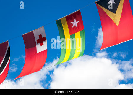 Colourful world country flags against a blue sky (Trinidad and Tobago, Tonga, Togo, East Timor) Stock Photo