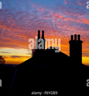 Wimbledon, London, UK. 22nd November, 2015. Chimney tops are silhouetted behind a fire sky during a colourful sunrise, on a cold November morning Credit:  amer ghazzal/Alamy Live News Stock Photo
