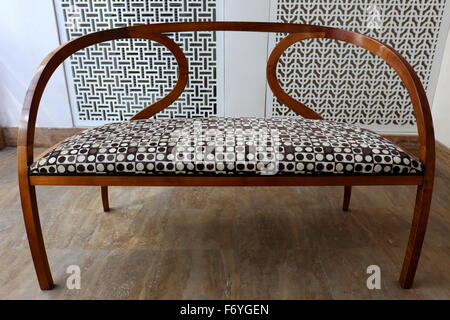 Elegant wooden sofa upholstered in geometrical style, inside the Ibrahim al Arrayed House of Poetry, Manama, Kingdom of Bahrain Stock Photo