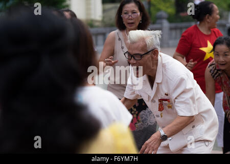 Members of the Hanoi Laughter Yoga Club gather early every morning at the Ly Thai To monument near the Hoan Kiem lake Stock Photo