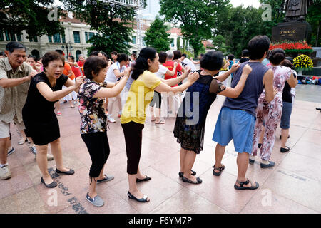 Members of the Hanoi Laughter Yoga Club gather early every morning at the Ly Thai To monument near the Hoan Kiem lake Stock Photo