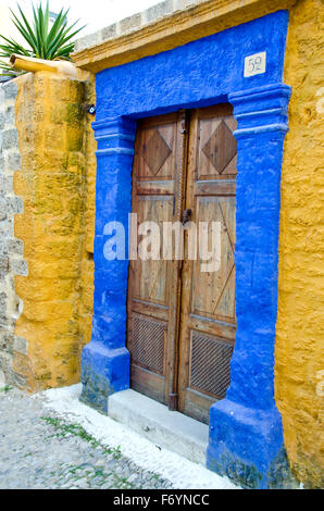 Antique doorway in Greek island painted yellow and blue. Architecture detail Stock Photo