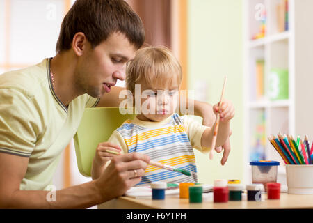 kid boy and daddy paint together Stock Photo