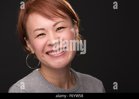 A headshot of a smiling middle aged Japanese woman. Stock Photo