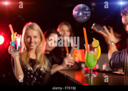 Young friends drinking cocktails together at party Stock Photo