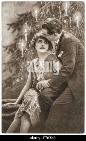 Young couple in love celebrated with christmas tree. Vintage picture with original film grain and blur Stock Photo