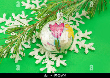 Decoupage decorated Christmas ornament ball with a snowflake and a fir tree. Christmas and winter time abstract Stock Photo
