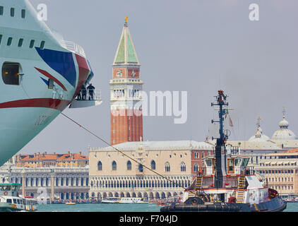 Tugboat leading a cruise liner down the San Marco canal past the Doge's Palace and St Mark's campanile Venice Veneto Italy Stock Photo
