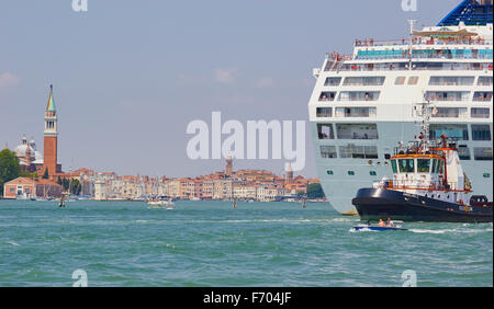 Tugboat leading a giant cruise liner down the San Marco canal Venice Veneto Italy Europe Stock Photo