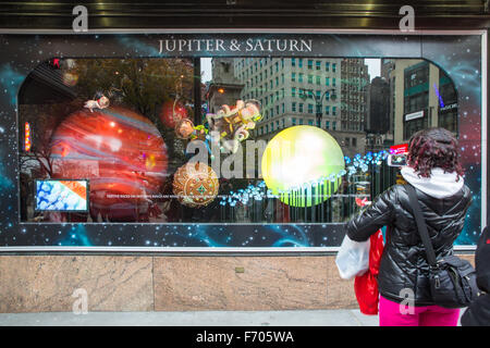 Pictured here is a view of  decorated holiday window Macy's Herald Square in midtown Manhattan with a person viewing it. Stock Photo