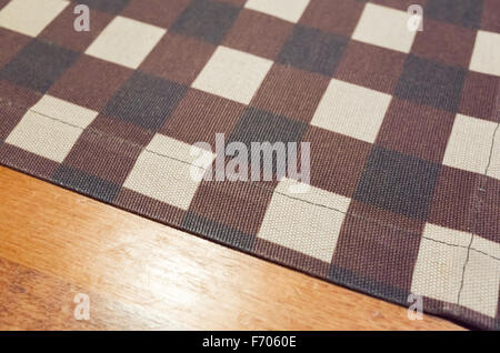 Tablecloth with checker pattern over wooden table, photo background with selective focus Stock Photo