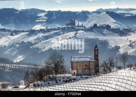 Small rural church and vineyards covered with snow in Piedmont, Northern Italy. Stock Photo