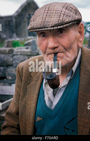 An Irish man smokes his pipe. Burren, Ireland. Stock Photo