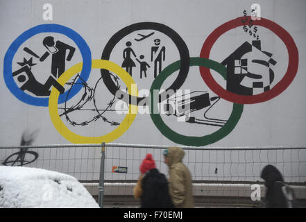 Passanten gehen am 22.11.2015 an einem Plakat mit den Olympischen Ringen an der Roten Flora in Hamburg vorbei. Am 29.11.2015 findet in Hamburg und Kiel ein Referendum zu der Bewerbung für die Olympischen Spiele 2024 statt. Foto: Marcus Brandt/dpa Stock Photo