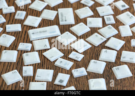Different computer keys lying on a wooden table. Stock Photo