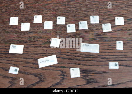 Different computer keys lying on a wooden table, word technology. Stock Photo