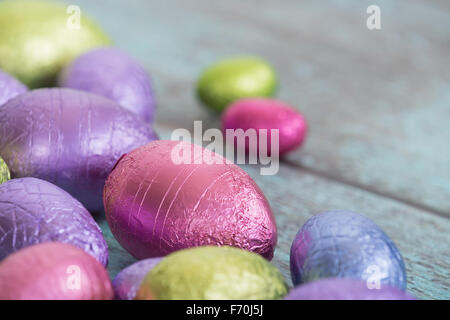 Pastel color Easter chocolate eggs on vintage green wooden background Stock Photo