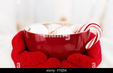 Red cup of hot chocolate with marshmallows and a candy cane Stock Photo