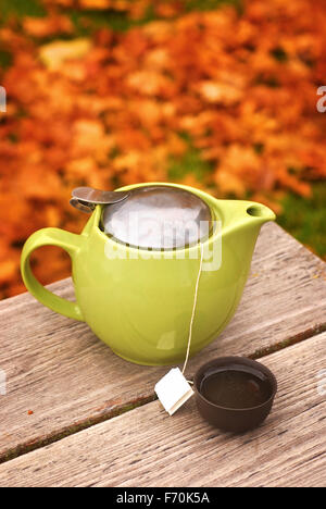 yellow autumn leaves Tea Cup on a red background Stock Photo - Alamy