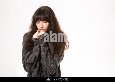 Portrait of a young woman with closed eyes standing isolated on a white background Stock Photo