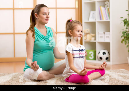 Pregnant woman and her daughter meditating in the bedroom Stock Photo: 51381754 - Alamy