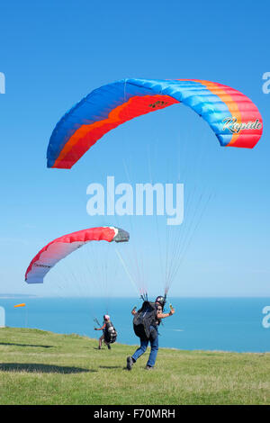 Two paraglider pilots prepare for a forward take off at Beachy Head, East Sussex, UK Stock Photo