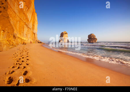 Footsteps on the beach at the Twelve Apostles along the Great Ocean Road, Victoria, Australia. Photographed at sunset. Stock Photo