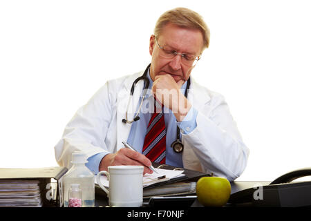 Physician sitting at a desk and taking notes Stock Photo