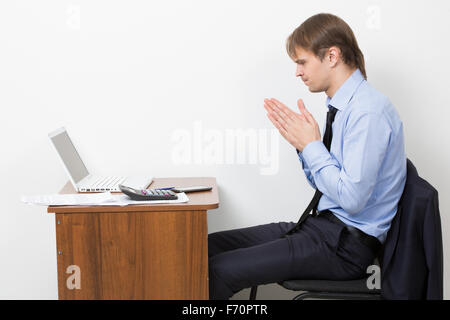 businessman working in bright office, sitting at desk, using laptop. Stock Photo