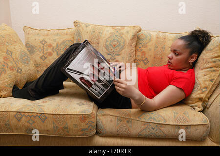 Heavily pregnant young woman resting on the sofa, Stock Photo