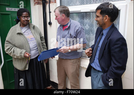 A group of people involved in development partnership working; handing over the keys to new tenant, Stock Photo