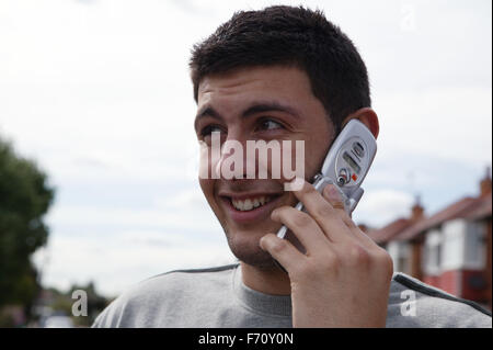 Young man outside using a mobile telephone; model released for use in HIV and Aids, Stock Photo