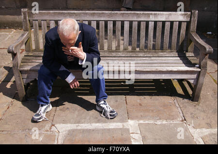 Man sitting on a bench smoking; Community Care Project user, Stock Photo