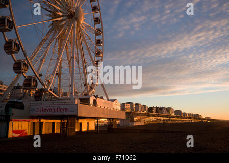 Brighton ferris wheel and Kemptown seafront illuminated by the rising sun Stock Photo