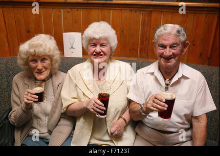 A group of elderly friends enjoying a drink in the pub, Stock Photo